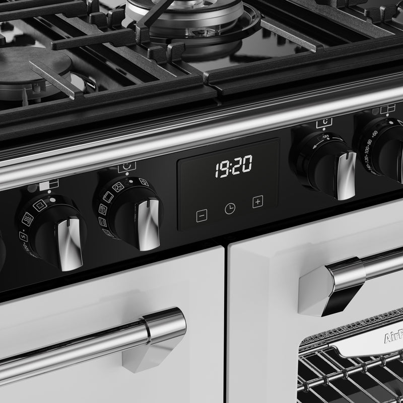 Close-up of ice white 100cm dual fuel range cooker control panel with silver knobs and digital clock, Free Delivery. - DB Domestics