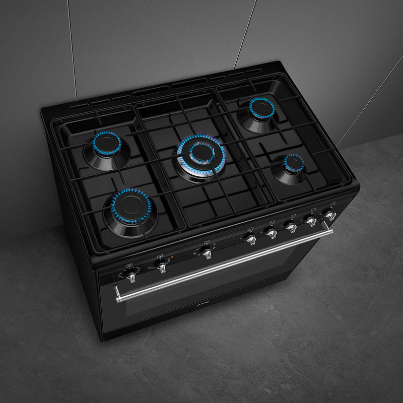 Black Smeg 90cm dual fuel range cooker with five burners and blue flame accents, available in Eastbourne and Uckfield with. - DB Domestics